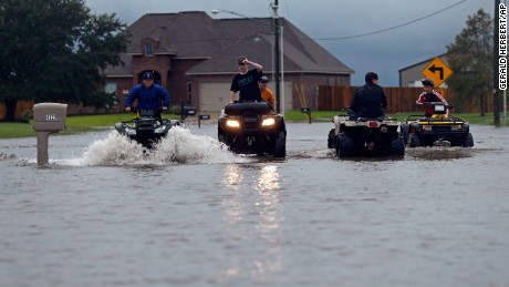 Kids ride an ATV in a street flooded by Tropical Storm Harvey, in the Clearfield Farm subdivision in Lake Charles, La., Tuesday, Aug. 29, 2017. (AP Photo/Gerald Herbert)