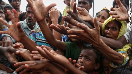 TOPSHOT - This August 30, 2017 photo shows Rohingya refugees reaching for food aid at Kutupalong refugee camp in Ukhiya near the Bangladesh-Myanmar border.
The International Organization for Migration said August 30 that at least 18,500 Rohingya had crossed into Bangladesh since fighting erupted in Myanmar&#39;s neighbouring Rakhine state six days earlier.
 / AFP PHOTO / STR        (Photo credit should read STR/AFP/Getty Images)