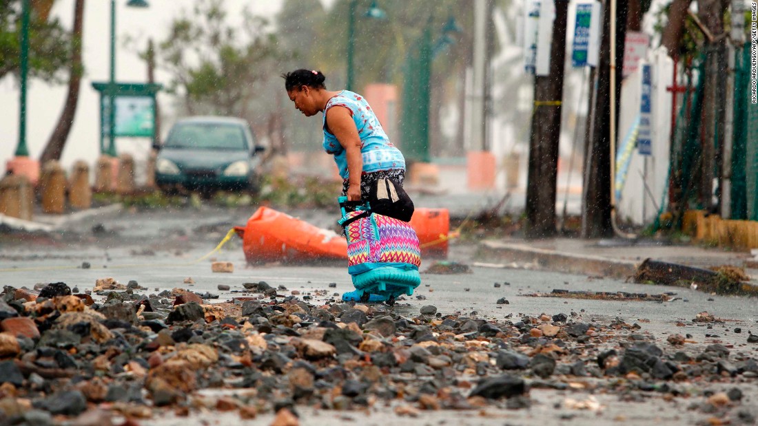 A woman makes her way through debris in Fajardo, Puerto Rico, on September 7.