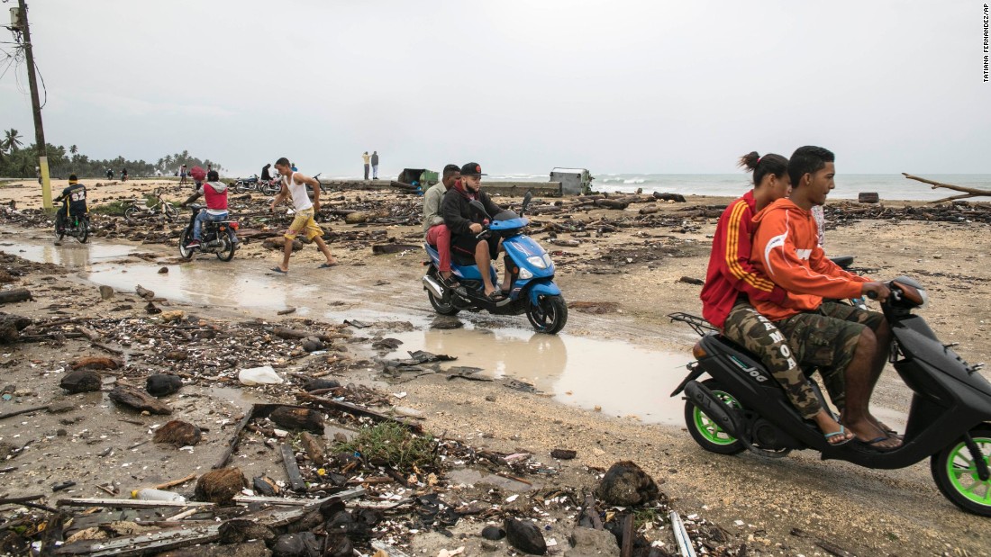 Nagua residents ride through an area affected by the storm on September 7.