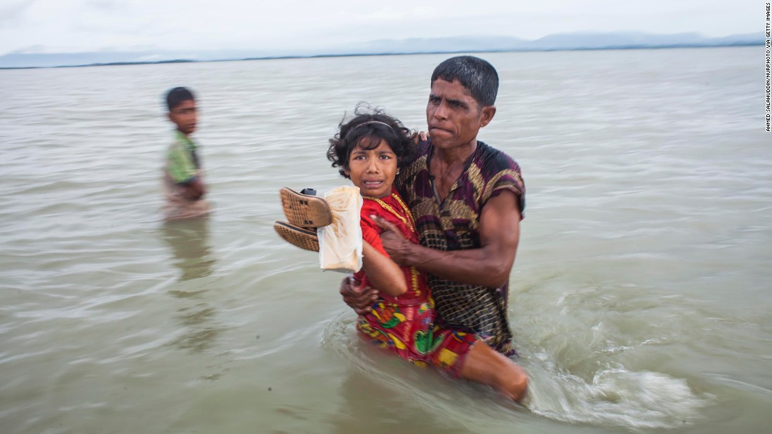 A girl is carried to safety after crossing the Naf River on September 9.