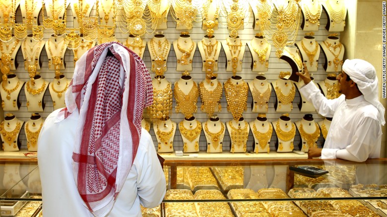 A gold merchant entices a potential customer with his jewelry at the Dubai Gold Souk in Dubai.