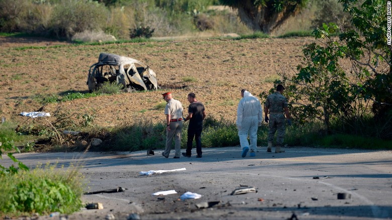 Police and forensic experts inspect the wreckage of the car following the explosion on Monday.