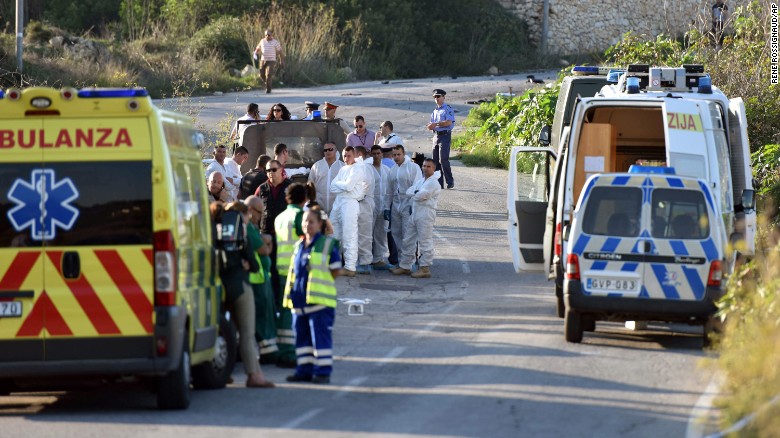 An ambulance is parked along the road where a car bomb exploded, killing investigative journalist Daphne Caruana Galizia.