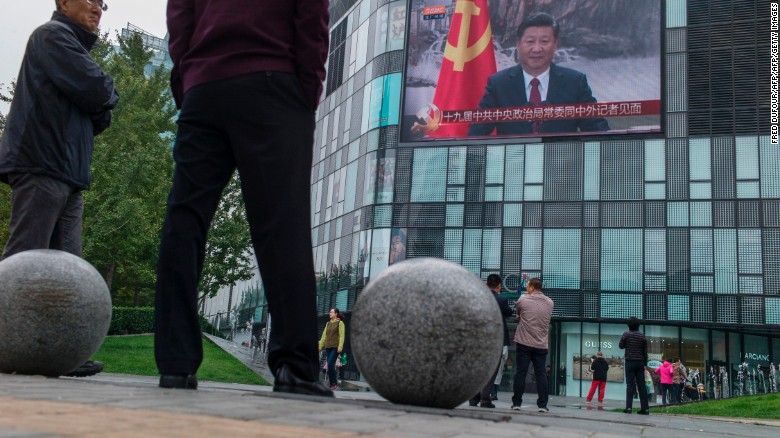 Residents watch a large screen showing Chinese President Xi Jinping revealing the new Politburo Standing Committee, the nation&#39;s top decision-making body at the Great Hall of the People in Beijing on October 25, 2017.
