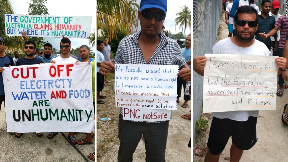 Manus Island refugees hold signs during a daily protest calling for the Australian government to find another solution.