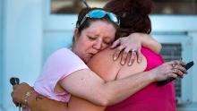 Carrie Matula embraces a woman after the shooting. Matula said she heard the shooting from the gas station where she works across the street.