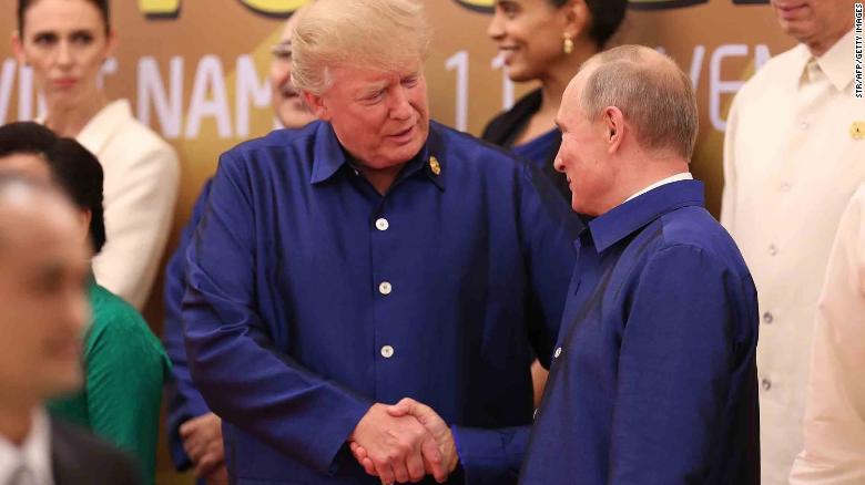 US President Donald Trump shakes hands with Russia's President Vladimir Putin as they pose for a group photo ahead of the Asia-Pacific Economic Cooperation (APEC) Summit leaders gala dinner in the central Vietnamese city of Danang on November 10, 2017.