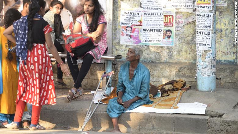 An Indian man begs on a sidewalk in Hyderabad on November 10. 
