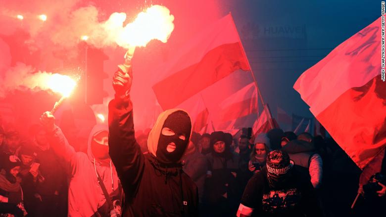 Demonstrators burn flares and wave Polish flags during the annual march to commemorate Poland's National Independence Day.