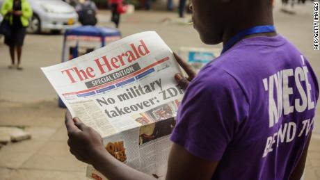 A man reads the front page of a special edition of The Herald newspaper about the crisis in Zimbabwe on November 15 in Harare.