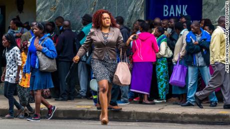 Residents in Zimbabwe&#39;s capital line up to withdraw money from the bank on November 15.