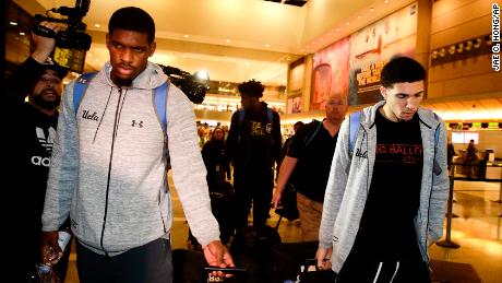 UCLA basketball players Cody Riley, left, LiAngelo Ball, right, and Jalen Hill, background center, are surrounded by the media as they leave the Los Angeles International Airport on Tuesday, Nov. 14, 2017, in Los Angeles. The three UCLA basketball players detained in China on suspicion of shoplifting returned home, where they may be disciplined by the school as a result of the international scandal. 