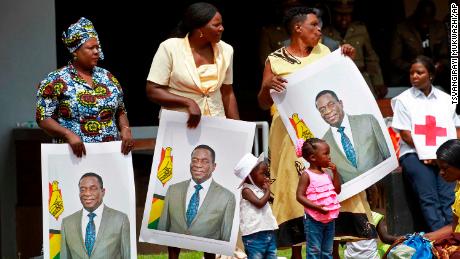 Supporters hold portraits of Emmerson Mnangagwa at his inauguration.