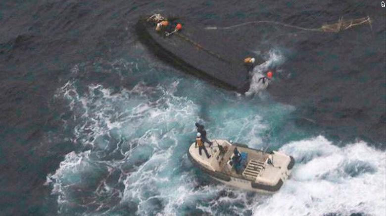 A Japan Coast Guard boat approaches a capsized wooden vessel, on Wednesday, Nov. 15, 2017. Three crew members rescued from the capsized boat are North Koreans, and Tokyo is arranging their return home. 