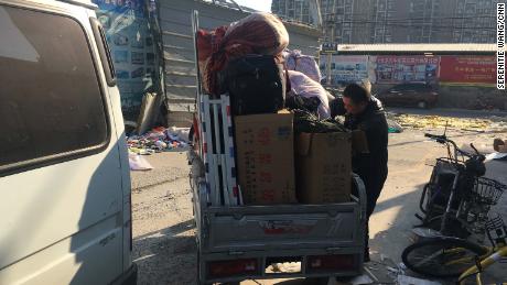 A migrant worker packs his things after being evicted from his rented apartment.