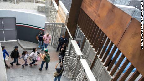 Central American migrants seeking for asylum in the United States walk to the US-Mexico border at El Chaparral port of entry in Tijuana, Mexico, on November