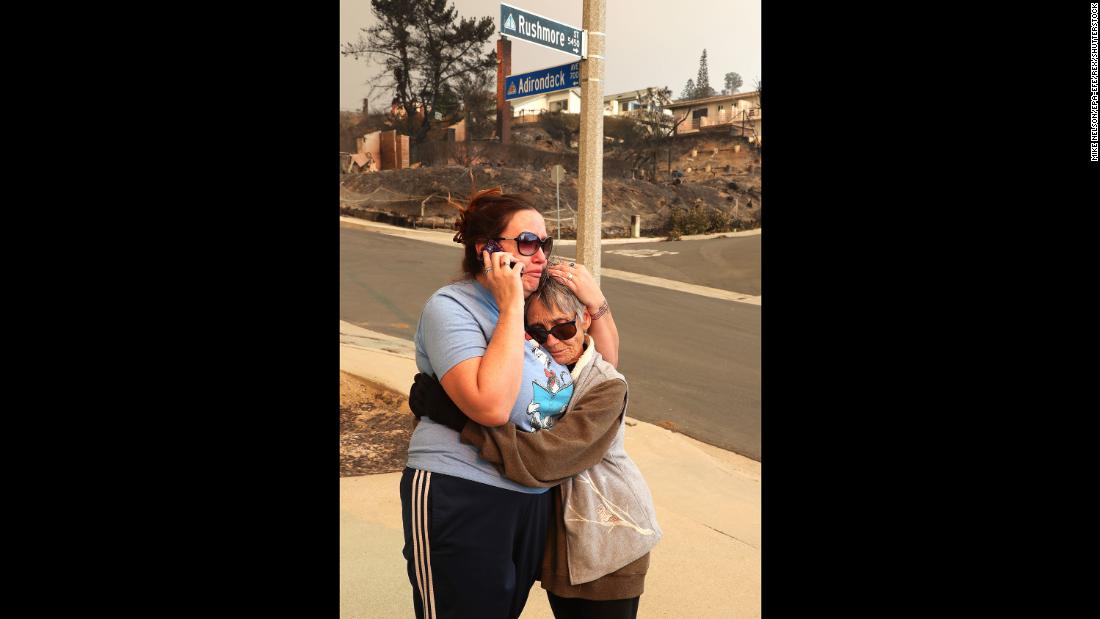 Joyce George, right, comforts neighbor Dawn Reily on December 6. Reily&#39;s Ventura home was destroyed by fire.