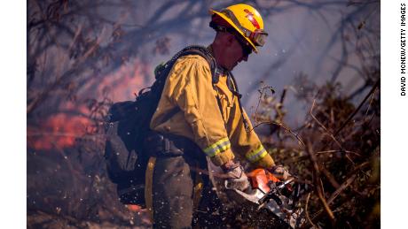 A firefighter cuts brush at the Thomas Fire on December 7, 2017, near Fillmore, California.