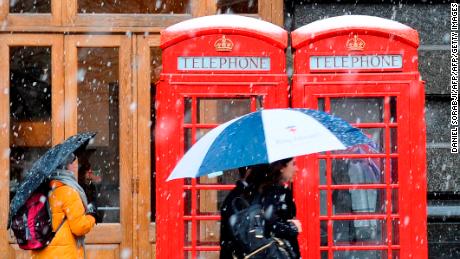 Snow falls on crowds in central London on Sunday.