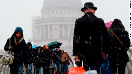 Pedestrians cross the Millennium Bridge in central London.
