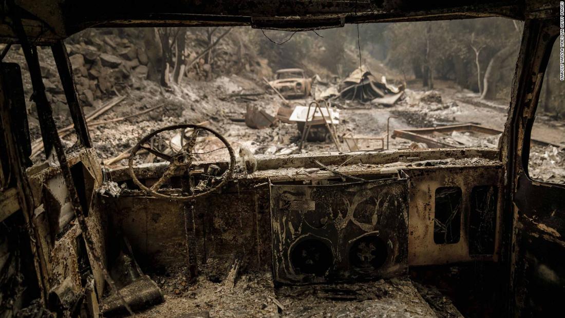 The shell of a burnt-out bus is seen after fire swept through residential neighborhoods near Ojai on Friday, December 8.