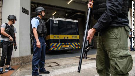 Armed police stand guard as British banker Rurik Jutting is driven in a prison van into the High Court for an appeal hearing in Hong Kong on December 12, 2017.