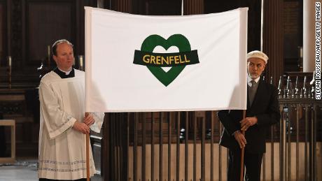 Attendees hold a banner at the Grenfell Tower National Memorial Service at St Paul&#39;s Cathedral in London.