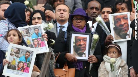 Mourners hold portraits of victims as they leave St Paul&#39;s cathedral after attending a Grenfell Tower National Memorial service.
