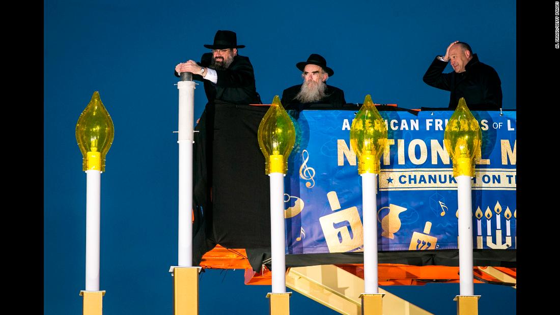 Rabbi Levi Shemtov, left, helps during the National Menorah Lighting in Washington on Tuesday, December 12. Hanukkah ends on December 20 this year.