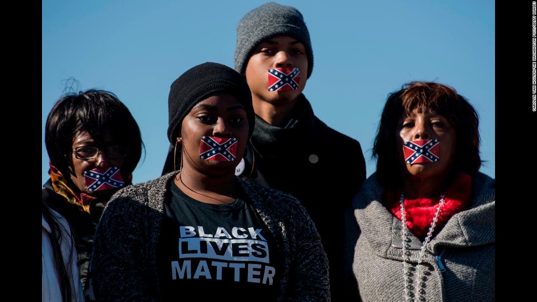 People in Jackson, Mississippi, protest in silence during the opening of the Mississippi Civil Rights Museum on Saturday, December 9. They were protesting against the Mississippi state flag, which still includes the Confederate battle flag in its upper-left corner.