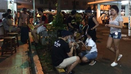 Residents gather outside their apartment blocks in Jakarta after the earthquake.