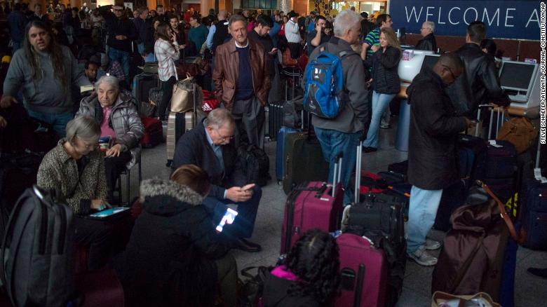 Passengers wait in a dark terminal at Hartsfield-Jackson International Airport.