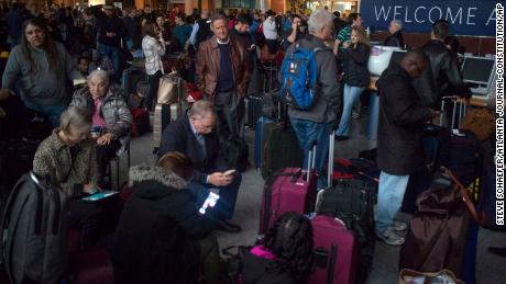 Passengers wait in a dark terminal at the Atlanta airport Sunday. 