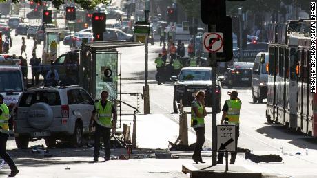 A white SUV (L) sits in the middle of the road as police and emergency personnel work at the scene of where a car ran over pedestrians in Flinders Street in Melbourne on December 21, 2017.
The car ploughed into a crowd in Australia&#39;s second-largest city on December 21, injuring at least a dozen people, some of them seriously, officials said. / AFP PHOTO / Mark Peterson        (Photo credit should read MARK PETERSON/AFP/Getty Images)