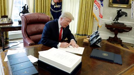 Trump signs tax bill before leaving for Mar-a-Lago