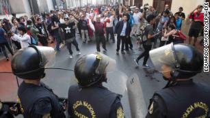 Riot police and protesters face off during a demonstration against the pardon to ex-president Alberto Fujimori, in Lima, Peru, on Monday.