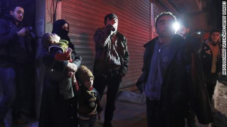 Syrian civilians wait during an evacuation operation in Eastern Ghouta on Tuesday.