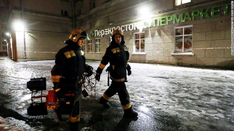 Firefighters outside a Perekrestok supermarket in St. Petersburg where an explosion injured 10 people. 