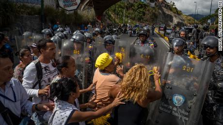 A group of protesters gather in front of members of the Bolivarian National Police in Caracas, Venezuela, on Thursday. 