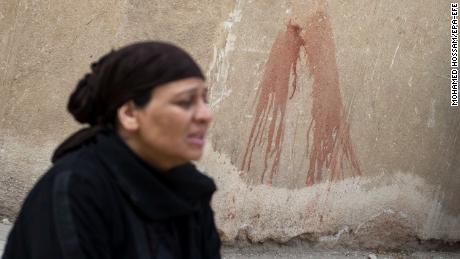 A woman walks past the St. Mina Coptic church following an attack on Friday. 