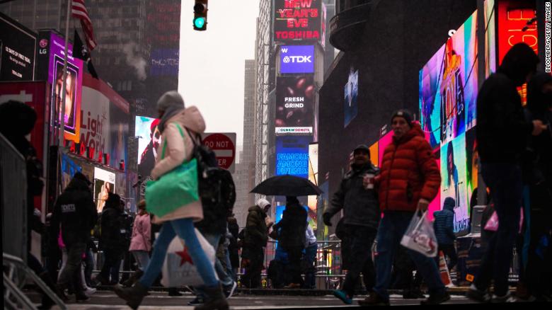 Pedestrians walk past the One Times Square building Saturday ahead of Sunday's New Year's Eve celebrations.