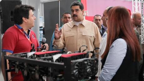 Venezuelan President Nicolas Maduro(C) speaks in front of a computer used to mine crypto currency Ethereum at the International Science and Technology Fair (FITEC) in Caracas on December 3, 2017.
Venezuela is creating a digital currency to combat a financial blockade by the United States, President Nicolas Maduro announced Sunday. The Petro will be backed by Venezuela's oil and gas reserves and its gold and diamond holdings according to Maduro. / AFP PHOTO / PRESIDENCIA        (Photo credit should read PRESIDENCIA/AFP/Getty Images)