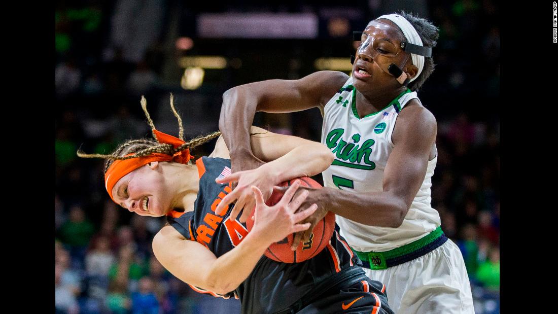 Syracuse&#39;s Tiana Mangakahia, left, wrestles for the ball with Notre Dame&#39;s Jackie Young during a college basketball game in South Bend, Indiana, on Thursday, December 28.
