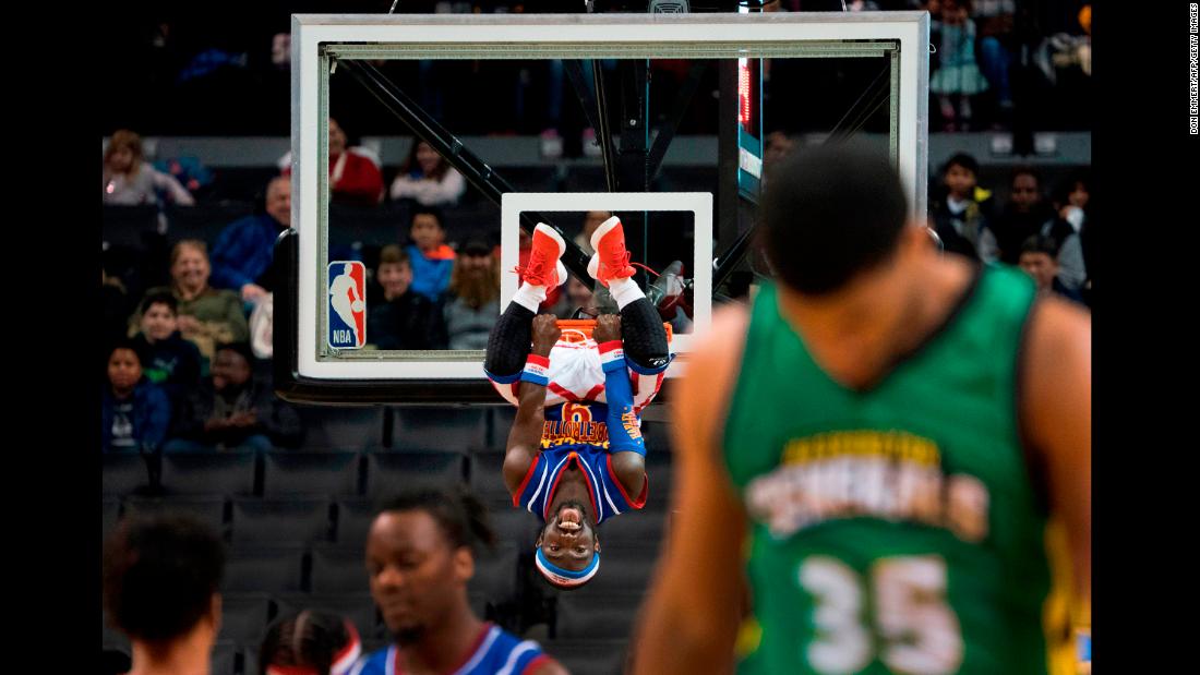 Jahmani &quot;Hot Shot&quot; Swanson, one of the Harlem Globetrotters, hangs on the rim after a dunk in New York on Tuesday, December 26.
