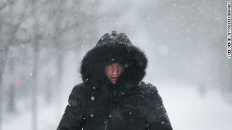 A man walks through the streets of Boston as the snow begins to fall from a massive winter storm on January 4 in Boston, Massachusetts. Schools and businesses throughout the Boston area are closed as the city is expecting over a foot of snow and blizzard like conditions throughout the day. 