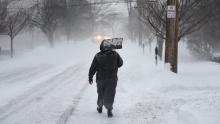 A man carries a shovel up the middle of a street in Greenwich, Connecticut, on January 4.
