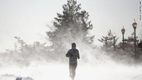 Gusty wind picks up snow accumulated on the ground as Jesse Sherwood, of Jersey City, N.J., jogs at Liberty State Park, Saturday, Jan. 6, 2018, in Jersey City. About 100 million people faced a new challenge after the whopping East Coast snowstorm: a gusty deep freeze, topped Saturday by a wind chill close to minus 100 on New Hampshire's Mount Washington that vied for world's coldest place. 