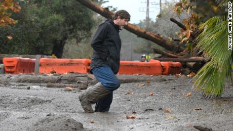 Carpinteria resident Scott Mayfield walks through the mud on Foothill Road in Carpinteria, Calif., Tuesday, Jan. 9, 2018. (AP Photo/Michael Owen Baker)