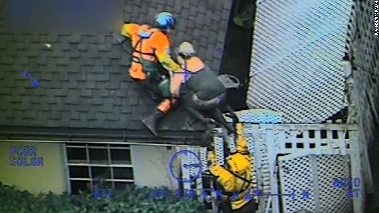 A Coast Guard helicopter crew pulls a person onto a roof after mud overtook a house in Carpinteria.